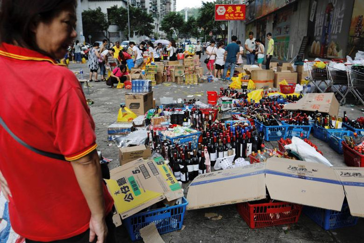 Nhân viên bán hàng hóa bên ngoài một siêu thị do mất điện ở Macau. Ảnh: Reuters.