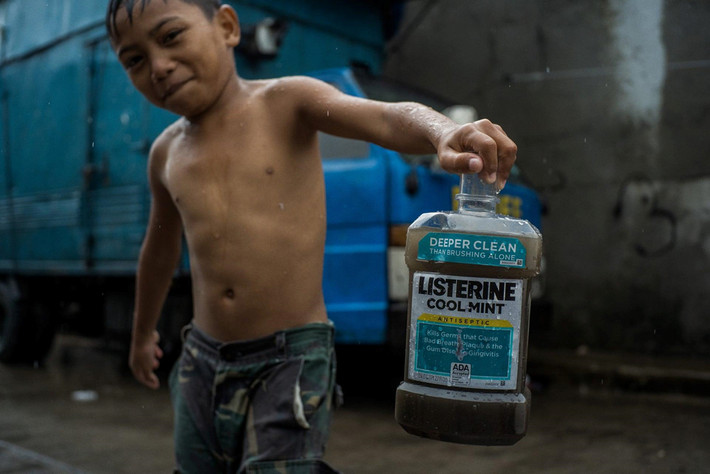 Một cậu bé chơi với một chai nhựa Listerine cũ. Thành phố Valenzuela là một mô hình thu nhỏ của một số vấn đề mà cộng đồng ở Đông Nam Á phải đối mặt, khi họ trở thành bãi thải rác thải nhựa thế giới. Ảnh: Guardian.