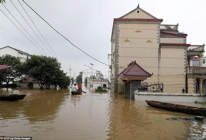 Người dân dùng thuyền để di chuyển qua con đường ngập nước ở Mã Vĩ, thành phố Phúc Châu, tỉnh Phúc Kiến.