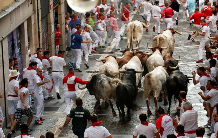 Những chú bò tót rượt đuổi người trên đường phố San Fermin ngày 8/7.