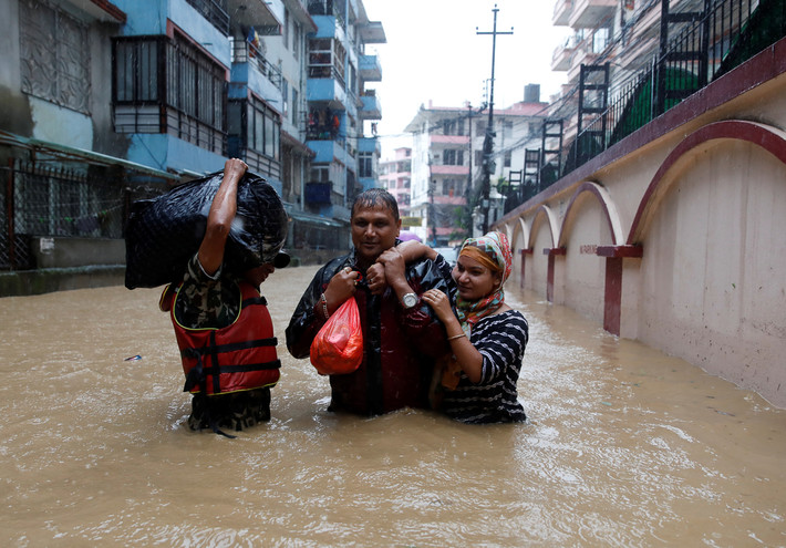 Người dân đi qua con phố ngập lụt ở Kathmandu. Ảnh: AJ.