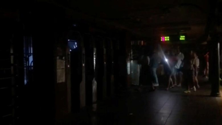 Hành khách đi bộ tại nhà ga tàu điện ngầm ở Manhattan trong bóng tối.