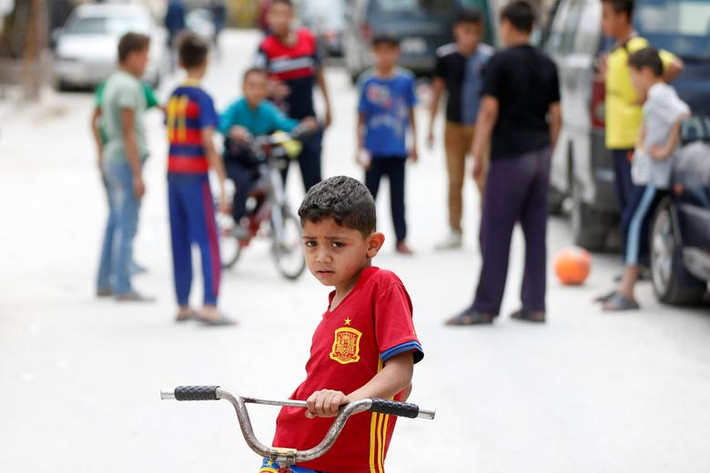 Bé trai tị nạn người Palestine đi xe đạp trong khu trại Al-Baqaa gần Amman, Jordan, ngày 13/6.