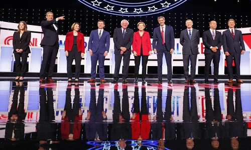 Từ trái sang phải: Nhà văn Marianne Williamson, Hạ nghị sỹ Tim Ryan, Thượng nghị sĩ Amy Klobuchar, Thị trưởng thành phố South Bend Pete Buttigieg, Thượng nghị sĩ Bernie Sanders, Thượng nghị sĩ Elizabeth Warren, cựu Hạ nghị sĩ Texas Beto O’Rourke, cựu Thống đốc Colorado John Hickenlooper, cựu Hạ nghị sĩ John Delaney và Thống đốc Montana Steve Bullock chụp ảnh trước khi bước vào phiên tranh luận tại Detroit hôm 30/7.