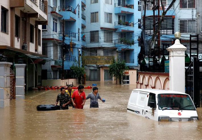 Người dân đi qua con đường ngập nước ở Kathmandu, Nepal, ngày 12/7.