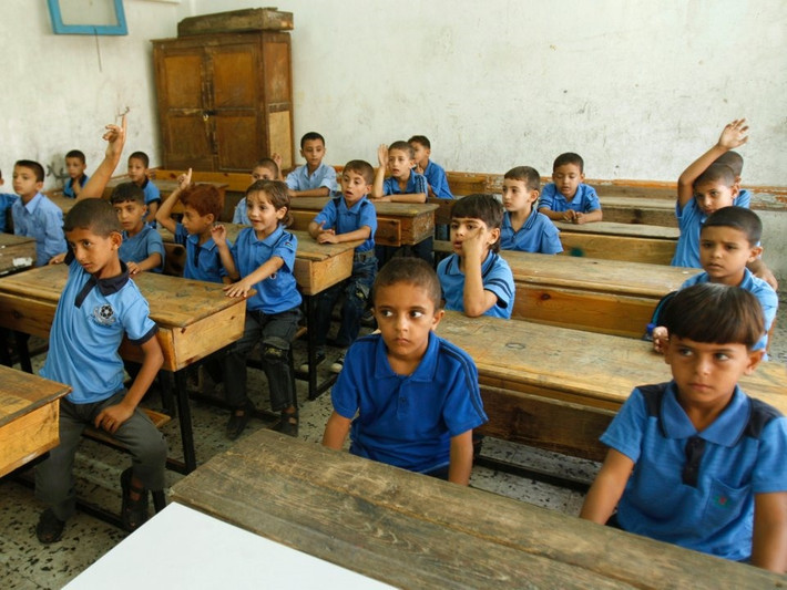 Trẻ em Palestine ngồi trong một lớp học trong ngày khai giảng năm học mới tại trường al-Shafi'i, thành phố Gaza. Ảnh: Reuters.