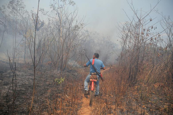 Người đàn ông Myky đi qua đám cháy rừng trên đường đi săn ở ngoại ô Brasnorte, bang Mato Grosso, ngày 29/8.