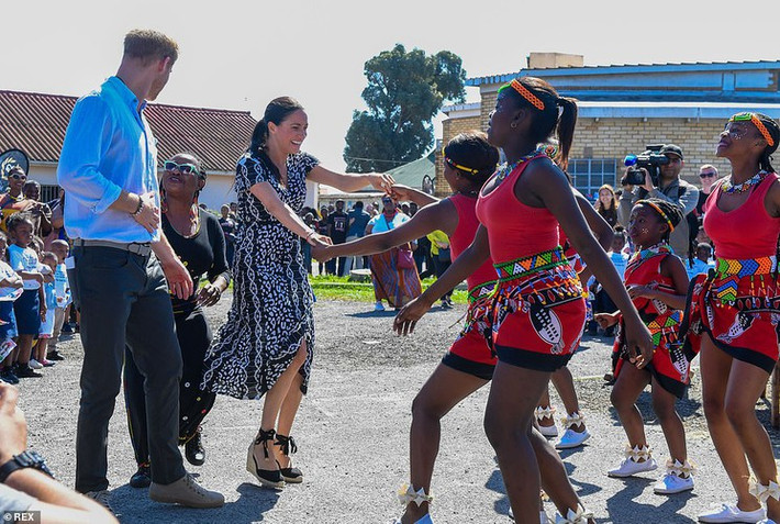Vài giờ sau khi hạ cánh, vợ chồng Công nương Meghan đã tới thăm thị trấn Nyanga, ngoại ô Cape Town, và có bài phát biểu trước đông đảo người dân địa phương. Ảnh: REX.
