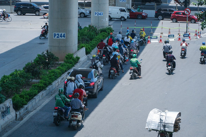 Trên đường Xuân Thủy, các phương tiện tận dụng bóng mát của đường sắt Nhổn - ga Hà Nội trong lúc chờ đèn đỏ.