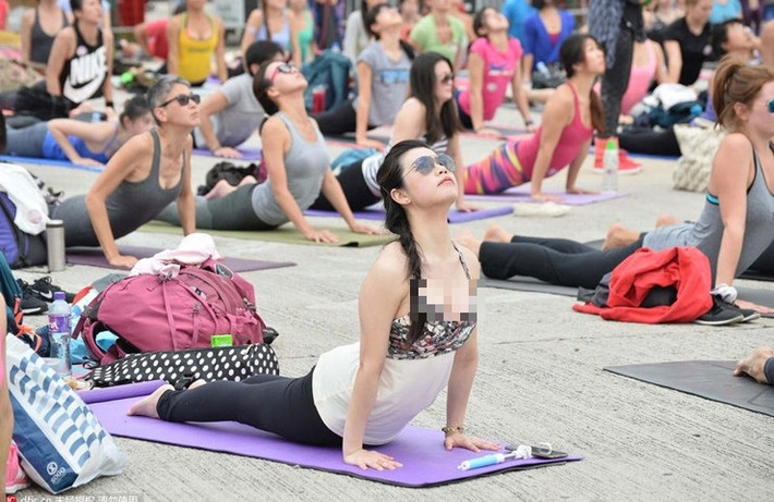 Trong hình, cô gái diện áo hai dây tập yoga ở chốn đông người.