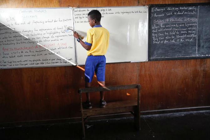 Cậu học trò người Nigeria đang viết lên bảng. “Cháu chưa bao giờ nhìn thấy trường học nào nổi trên mặt nước. Đây là ngôi trường duy nhất mà cháu được chứng kiến. Chính vì vậy cháu đã xin bố mẹ cho đi học”, bé Omodobu Emmanuel, 11 tuổi, chia sẻ.