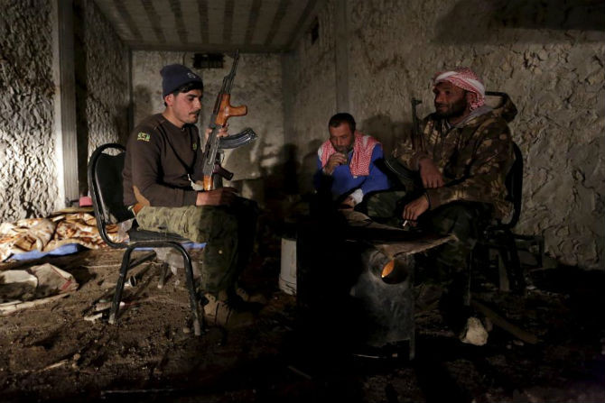 Các chiến binh nổi dậy của lữ đoàn Al-Furqan sưởi ấm tại làng Aziziyah, tỉnh Aleppo, ngày 5/3.