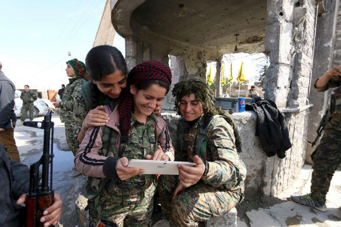 Nữ chiến binh đến từ Các Lực lượng Dân chủ Syria sử dụng máy tính bảng ở thị trấn al-Shadadi, tỉnh Hasaka ngày 26/2.