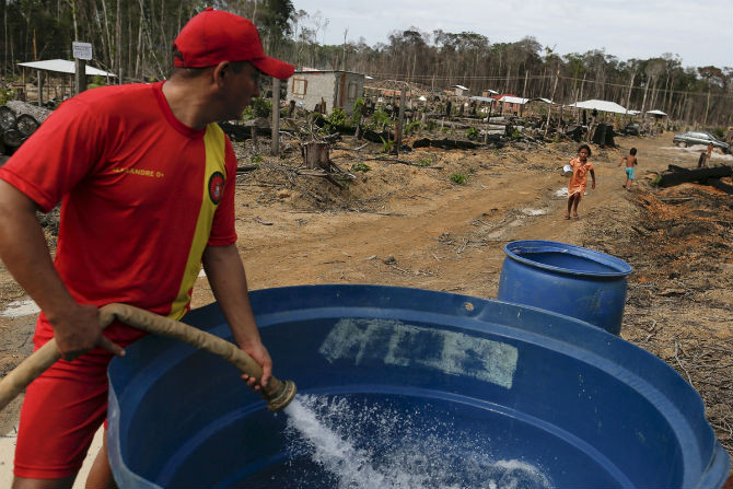 Một công nhân tháo nước vào thùng chứa gần hồ ở Presidente Figueiredo, bang Amazonas, Brazil, ngày 4/3/2016.