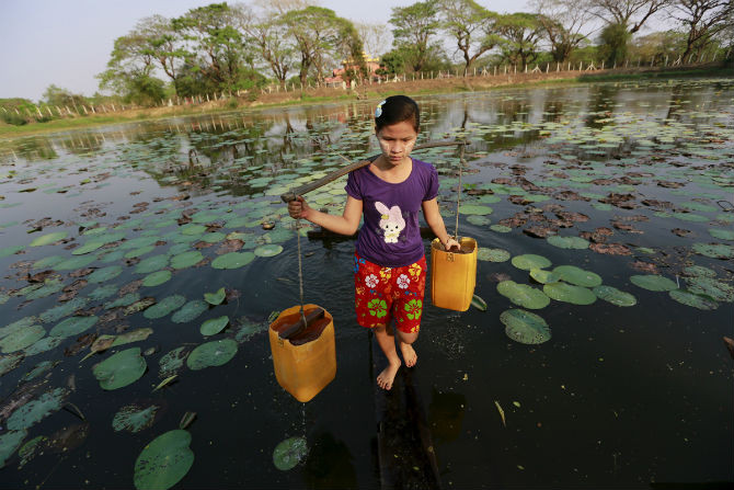 Bé gái gánh nước ở sông Dala, Myanmar ngày 3/3/2016.