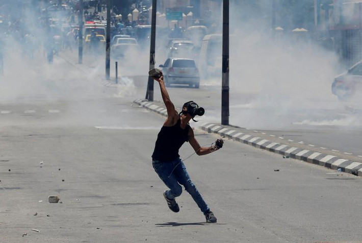 Người biểu tình Palestine ném đá về phía binh sĩ Israel trên đường phố Bethlehem.