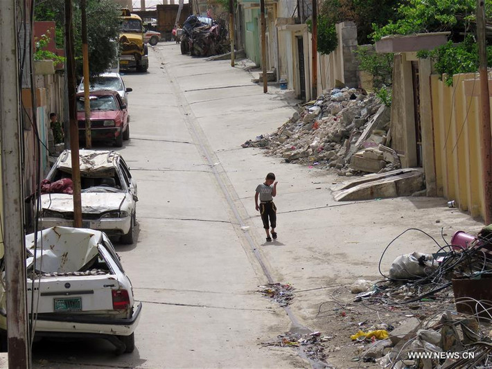 Một vài chiếc ô tô bị hư hại đỗ bên đường ở Tây Mosul, Iraq, ngày 11/5. Ảnh: THX.