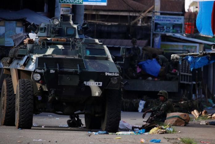 Một binh sĩ Philippines ngồi nghỉ cạnh xe chiến đấu bọc thép trên đường phố Marawi hôm 29/5.