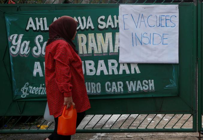 Người phụ nữ đang trên đường tới một trung tâm sơ tán ở Marawi hôm 28/5. Ảnh: Reuters.