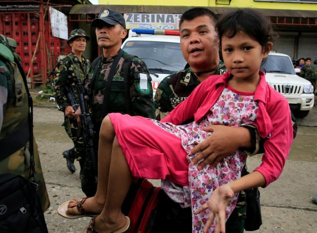 Binh sĩ Philippines bế một bé gái trên tay ở thành phố Marawi.