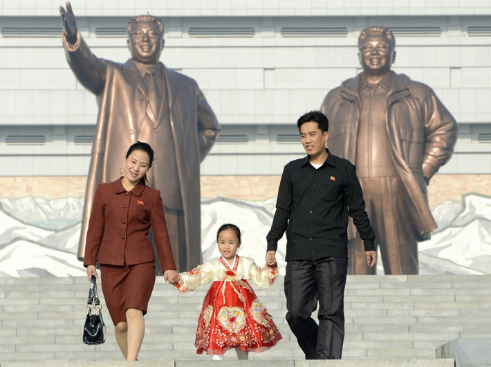 Một bé gái được bố mẹ đưa tới viếng tượng đài cố lãnh tụ Kim Il-sung và cố Chủ tịch Kim Jong-il. Ảnh: BI.