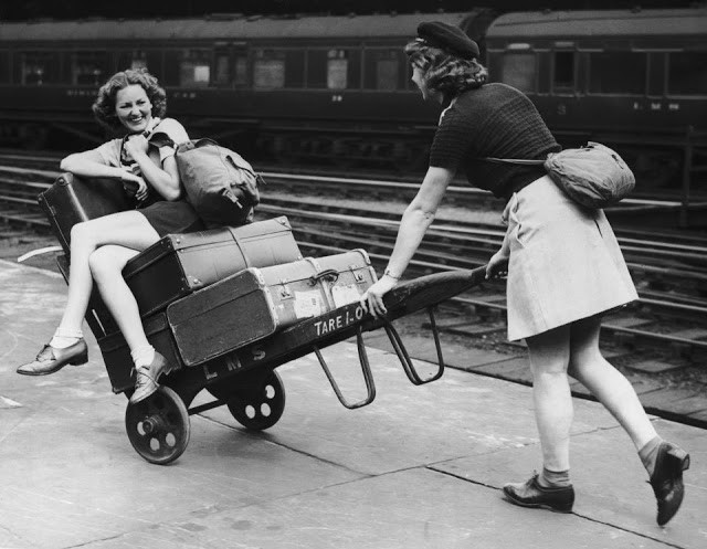 Hai cô gái đùa nghịch trong lúc chờ tàu tại nhà ga Euston năm 1939. Ảnh: VT.