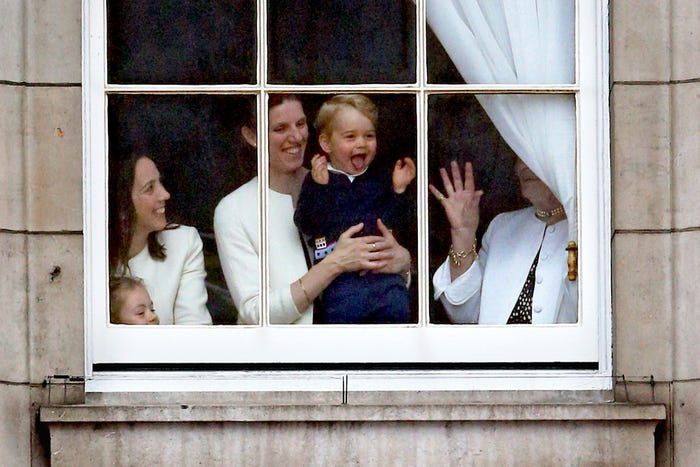 George đứng cạnh bảo mẫu tại Cung điện Buckingham trong khi cha mẹ cậu theo dõi cuộc diễu hành Trooping the Color hồi năm 2015.