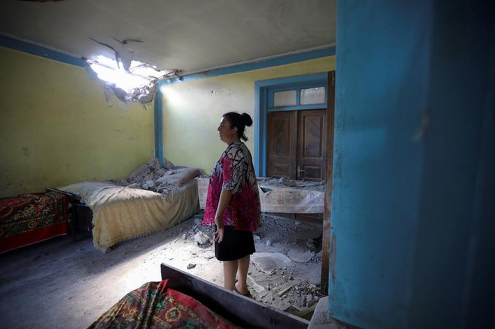 Người phụ xem xét ngôi nhà bị đạn pháo tàn phá ở Dondar Quschi, Azerbaijan, ngày 15/7.
