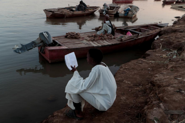 Một học sinh học bài trên bờ sông Nile ở Alqamayir, Omdurman, ngày 15/2/2020.