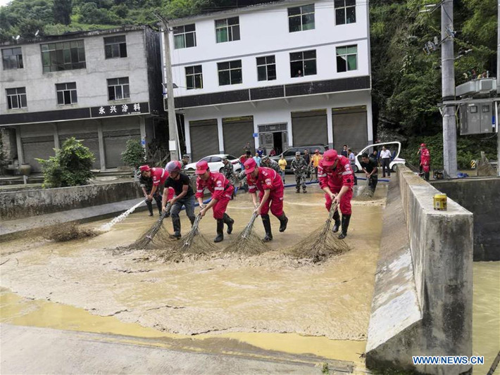 Các công nhân dọn dẹp cây cầu ở Kiềm Giang, Trùng Khánh, sau trận mưa lũ, hôm 2/7. Ảnh: News.cn.