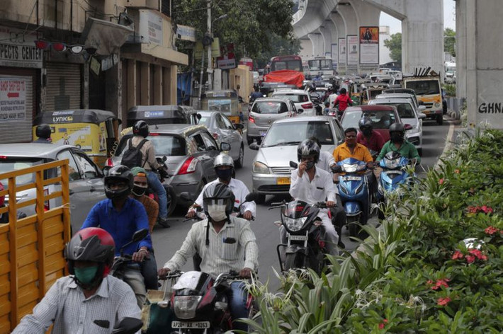 Người đi xe máy đeo khẩu trang trên đường phố ở Hyderabad.