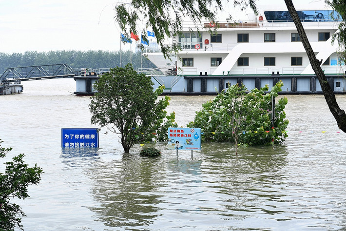 Tính đến ngày 12/7, lũ lụt đã gây thiệt hại kinh tế 11,75 tỷ USD trên toàn quốc, theo Tân Hoa Xã. Trong ảnh, biển báo giao thông ngập trong dòng nước lũ bên bờ sông Trường Giang ở thành phố Nam Kinh, tỉnh Giang Tô.