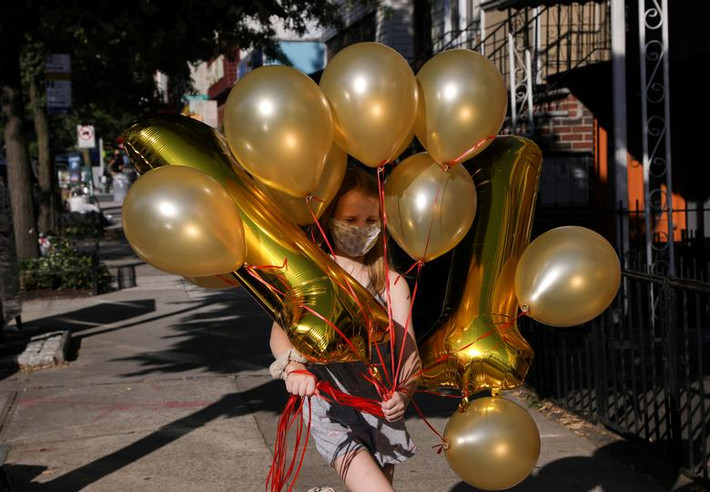 Lydia Hassebroek đeo khẩu trang, cầm những quả bóng bay trong ngày sinh nhật, tại Brooklyn, New York, hôm 12/7.