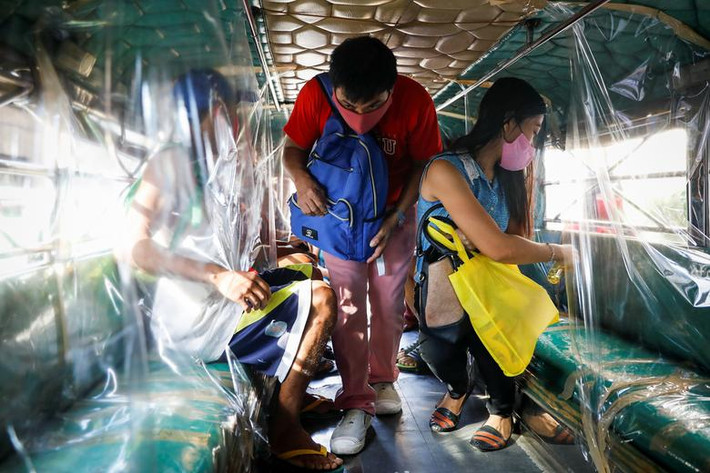 Hành khách đeo khẩu trang, xịt sát khuẩn chỗ ngồi trên xe jeepney ở thành phố Quezon, Metro Manila, Philippines, hôm 3/7.