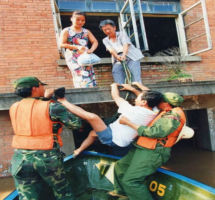 Người dân được giải cứu khỏi ngôi nhà bị ngập. Ảnh: Sohu.