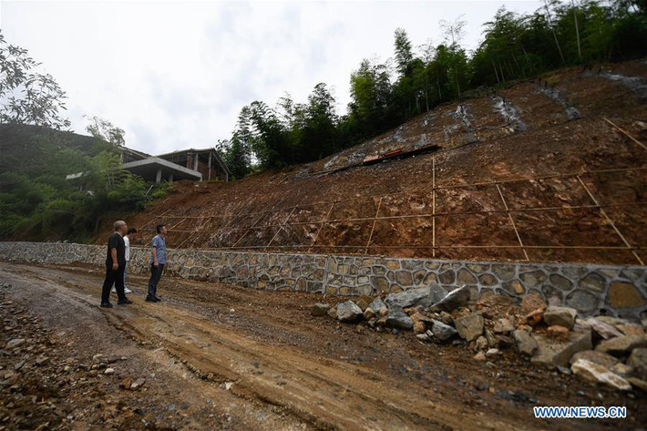 Thành viên ủy ban ứng phó khẩn cấp thị sát kè đá một sườn đồi đang được gia cố ở ngoại ô thành phố Hồ Châu, tỉnh Chiết Giang, phía đông nam Trung Quốc. Trong tuần qua, các cơ quan khí tượng và ứng phó thiên tai nước này đã cảnh báo nguy cơ sạt lở và lũ bùn vì mưa lớn và lũ lụt kéo dài. Ảnh: Tân Hoa xã.