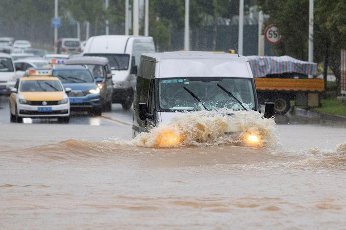 Ô tô di chuyển qua con đường ngập nước ở Vũ Hán, tỉnh Hồ Bắc, ngày 6/7.