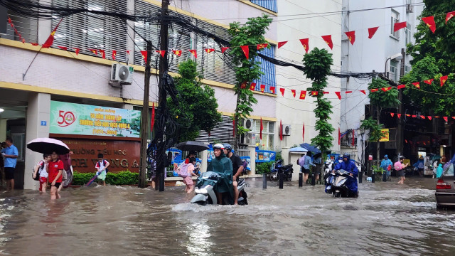 Đoạn đường trước cổng trường cũng bị ngập sâu nên việc đón con em của phụ huynh gặp nhiều vất vả. 331a94d500388a66d329.jpg