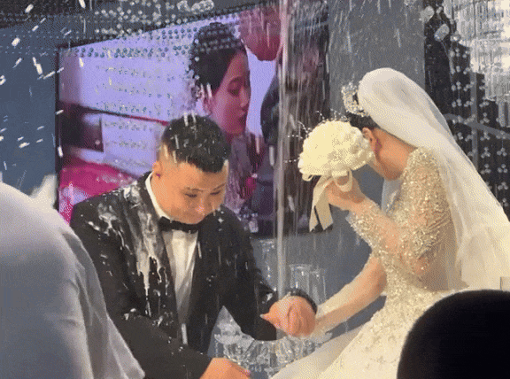 Mới đây, một đoạn video ghi lại cảnh một đám cưới tại Trung Quốc đã khiến nhiều người chú ý. Theo đó, khi cô dâu và chú rể mới chuẩn bị bước lên sân khấu để làm các nghi thức bắt đầu đám cưới thì một số người bạn đã xịt sâm panh vào mặt 2 vợ chồng, khiến chú rể dính phải rất nhiều bọt rượu, phải liên tục đưa tay lên xoa mặt.
