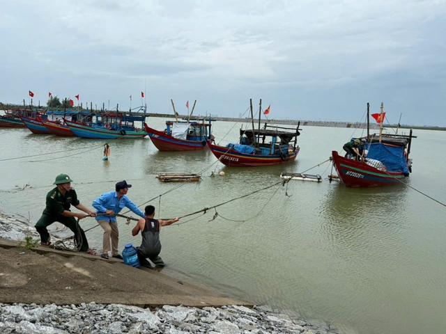 Lực lượng chức năng hỗ trợ người dân chằng néo tàu thuyền. bao-4-ghrf.jpg