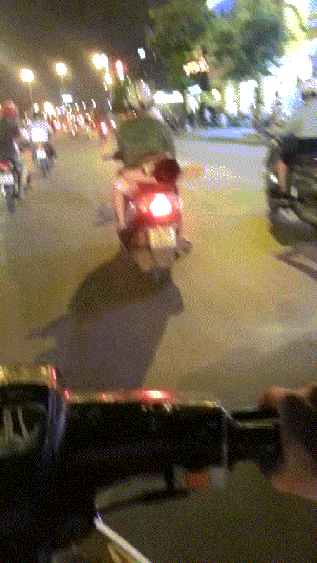 Cậu bé ngủ một cách ngon lành phía sau xe máy mẹ đang di chuyển với tốc độ cao trên đường.