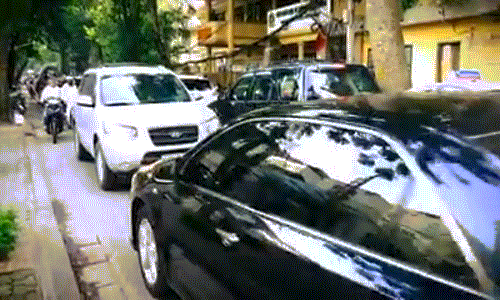 Chiếc xe biển xanh (màu đen) đi lấn làn bị xe biển trắng ép lùi lại. Ảnh cắt từ clip.