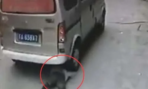 Cậu bé đứng dậy đi tiếp sau khi bị xe ôtô lăn qua người