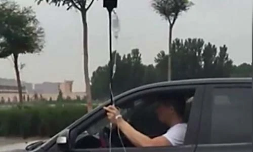 Thanh niên TQ vừa truyền dịch vừa lái xe và uống bia