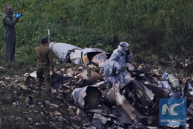 Lực lượng an ninh Israel đang kiểm tra phần còn lại của một máy bay chiến đấu F-16 của Không quân Israel, bị tên lửa phòng không của Syria bắn rơi gần làng Harduf, Israel ngày 10/2/2018. Ảnh Reuters 6.jpg
