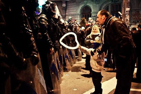 Vào năm 2012 tại Bucharest, Romania, một cậu bé đã không ngại ngần nắm tay cha tiến thẳng tới đội chống bạo động để trao cho một viên cảnh sát quả bóng bay hình trái tim.