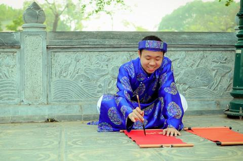 Ngoài những nơi cửa Phật linh thiêng, các bạn cũng có thể sắm vai ông đồ, bà đồ tự tay tạo nên những bức thư pháp cho chính mình. Trong ảnh là nam sinh Ngoại Thương múa bút viết thư pháp.