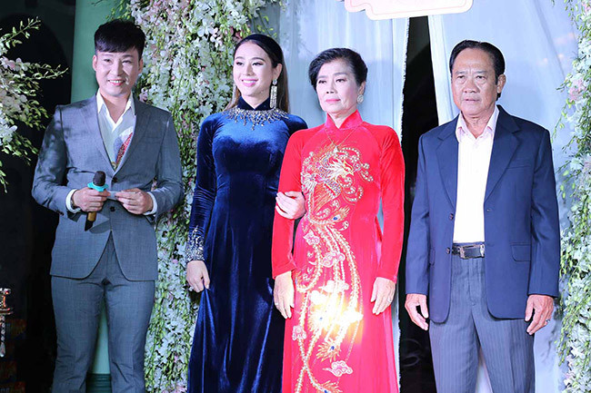 Lâm Khánh Chi bên bố mẹ trong ngày trọng đại. "Bố mẹ có hứa với tôi về món quà hồi môn từ lâu nên tôi không bất ngờ. Nhưng khi cầm chìa khóa nhà cùng lời dặn dò, tôi rất xúc động. Tôi kiếm được nhiều tiền nên không quan trọng vật chất. Tuy nhiên, tôi cảm nhận được sự lo lắng, hồi hộp của bố mẹ trước khi tôi lên xe hoa" - nữ ca sĩ cho hay.