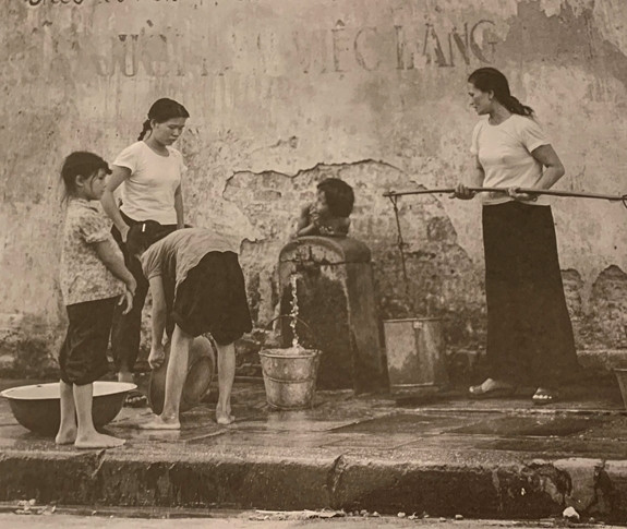 Nhiếp ảnh gia Thomas Billhardt lần đầu đến Việt Nam năm 1967 cùng một đoàn làm phim Cộng hòa Dân chủ Đức. Từ đây, ông đã chụp nhiều bức ảnh về cuộc sống của người dân Việt Nam. Trong ảnh là người dân đi gánh nước về dùng trong sinh hoạt hàng ngày.