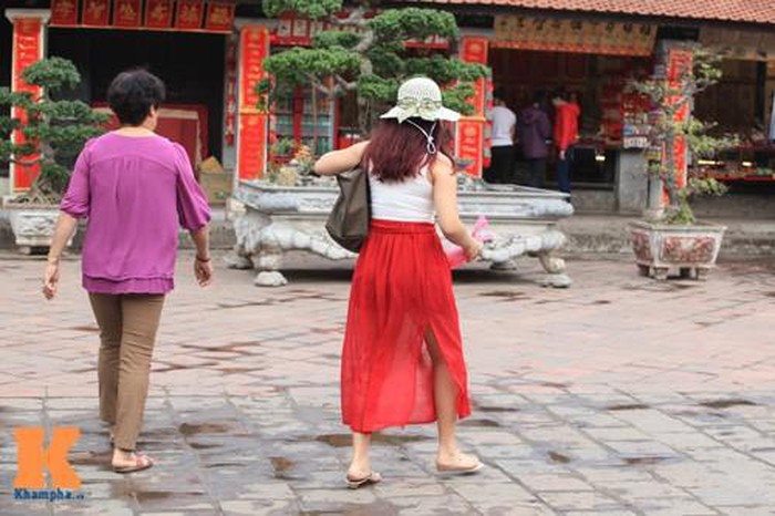 Cô gái đi lễ chùa với chiếc váy mỏng lòe loẹt và có đường xẻ cao. Ảnh: Khám phá. Video "Minh Hằng chia sẻ về phong cách thời trang". Nguồn: VTC.